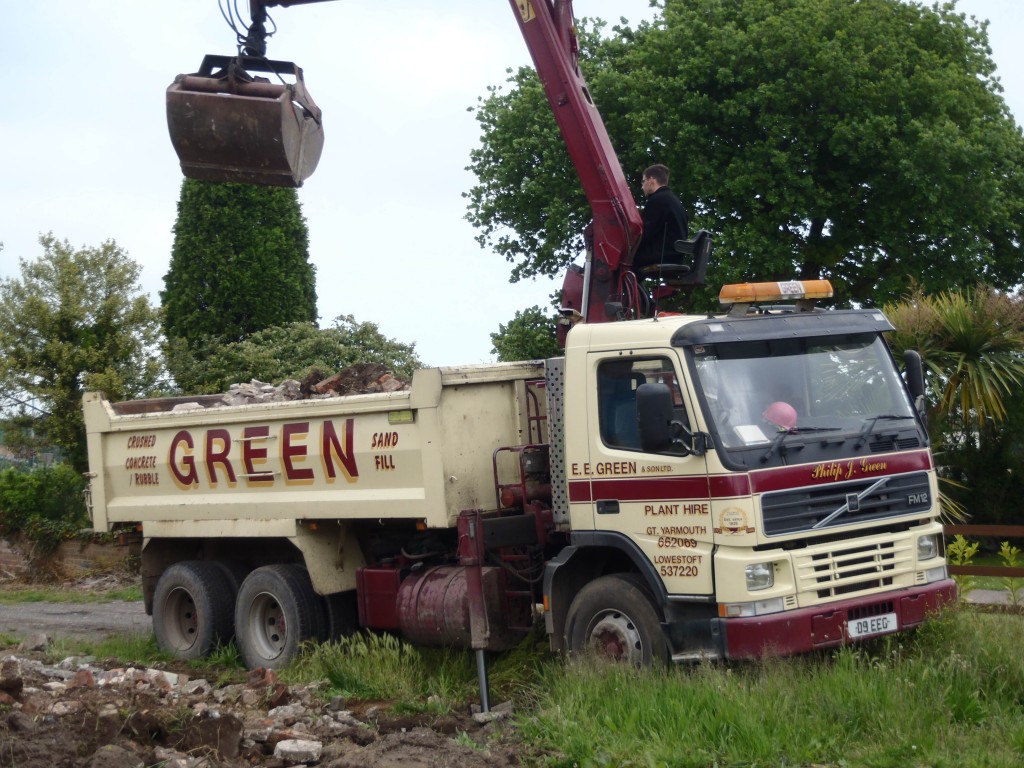 Grab lorry removing rubble.